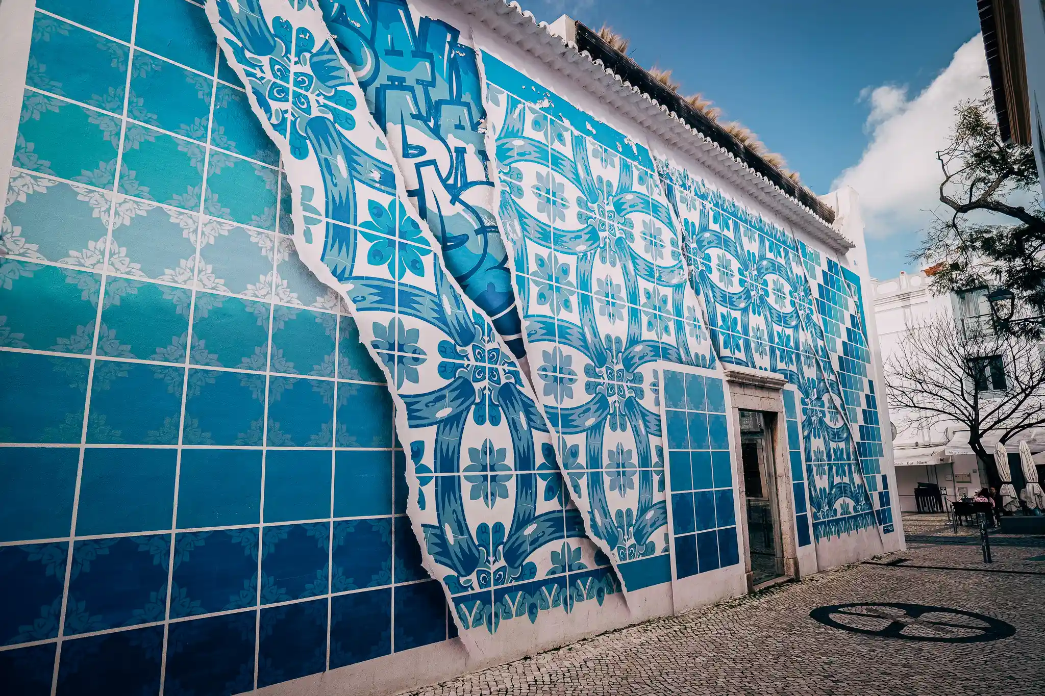 Mur d'azulejos bleus à Lagos, Portugal, avec un effet trompe-l'œil, ciel bleu en arrière-plan.