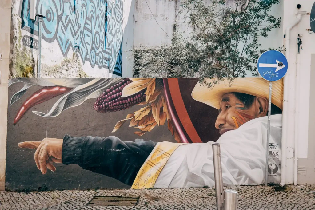 Fresque colorée de rue à Lagos, Portugal, représentant un homme en chapeau pointant, ambiance artistique et urbaine.