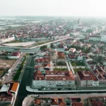 Aerial view of Aveiro, Portugal, with its picturesque canals and red roofs under a clear sky.