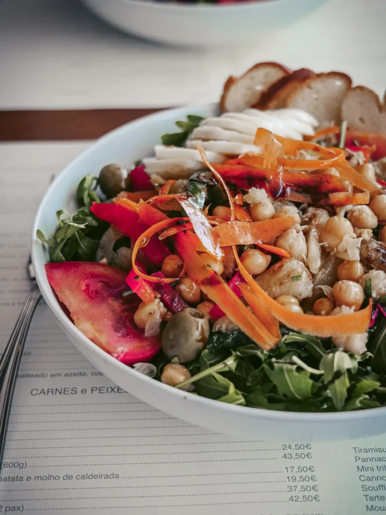 Colorful salad with chickpeas, cod, and fresh vegetables at the Madrigal restaurant in Aveiro, Portugal.