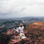 Caroline sitting at the top of Arthur's Seat overlooking Edinburgh