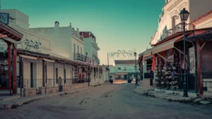 Main street of El Rocio in Andalusia, lined with white houses and traditional shops, calm atmosphere in winter with no visible human presence.