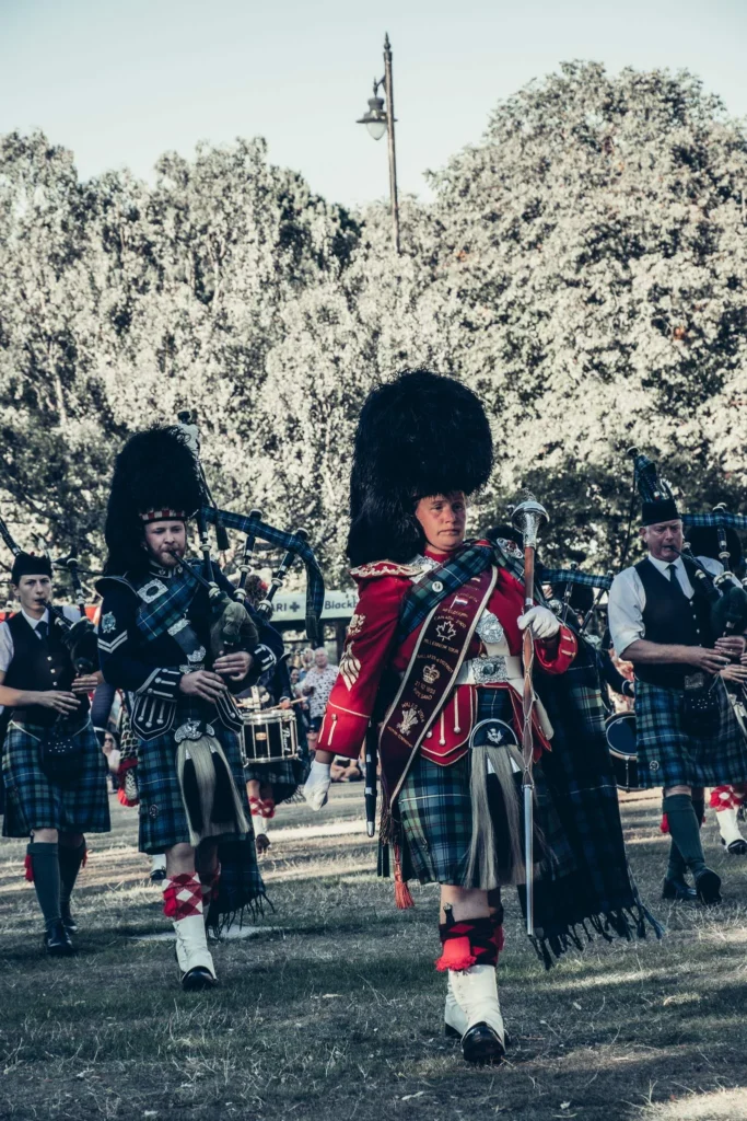 Parade of bagpipers in traditional Scottish attire at the Highland Games