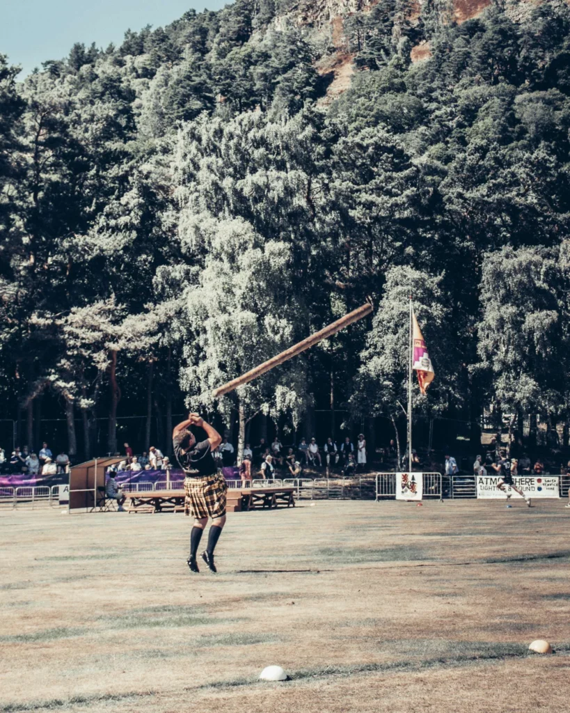 Athlete in a kilt throws a log during an event at the Highland Games