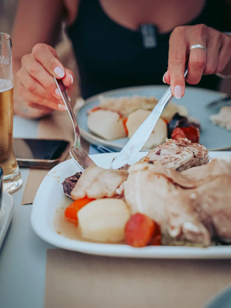 Caroline is enjoying a traditional dish made of meat, potatoes, carrots, and chorizo, typical of the O mané restaurant in Portimao, Algarve, Portugal, on May 24, 2026.