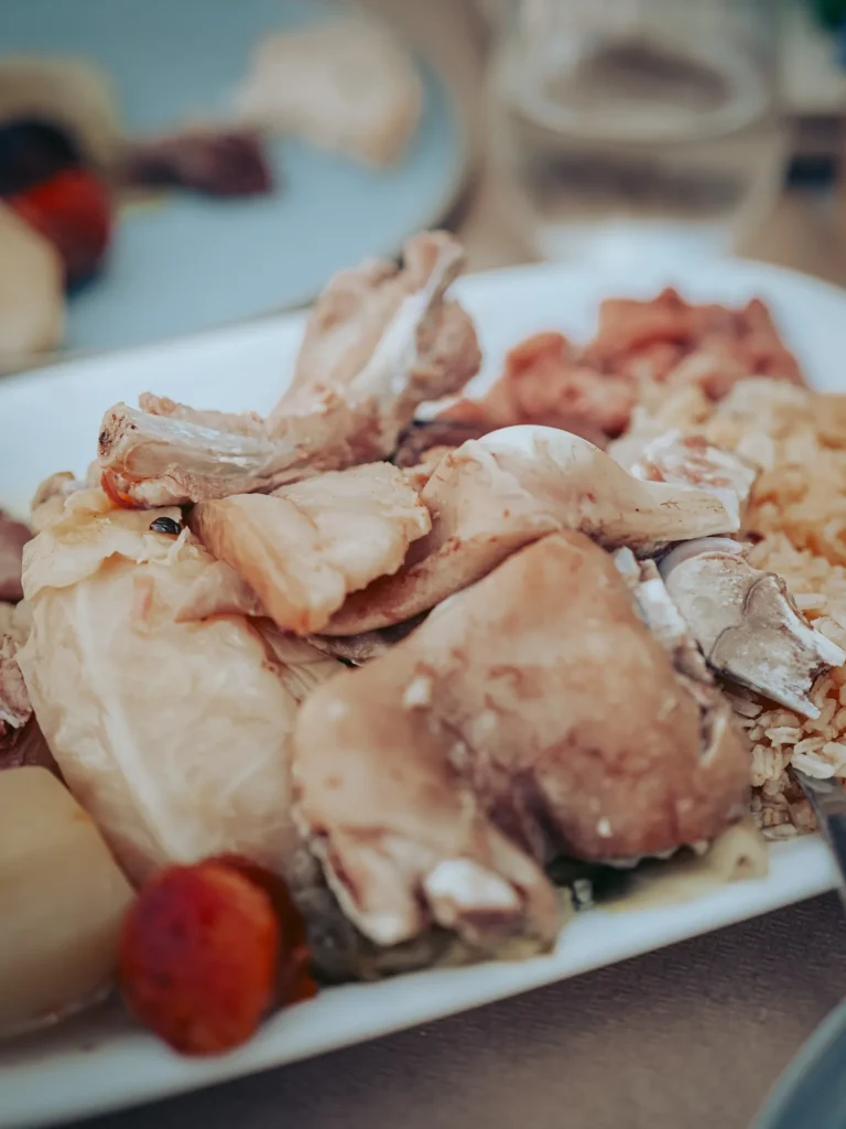 Plate of cozido à portuguesa served in a restaurant in Portimao, Algarve, with different cuts of meat, vegetables, and rice.
