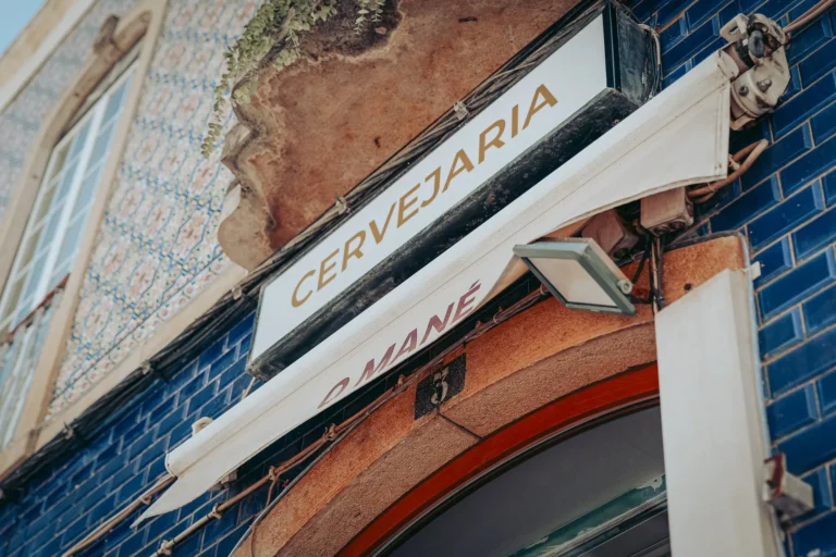 Facade of restaurant O Mané in Portimão, Algarve, with sign in dark blue tile.