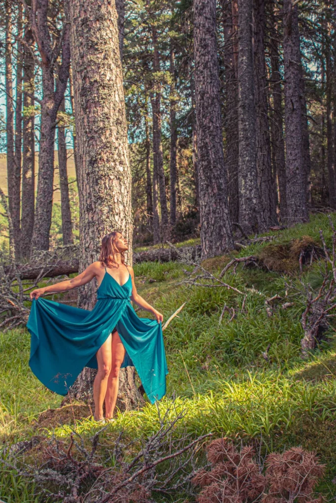 Caroline in a blue dress in a pine forest of the Cairngorms National Park