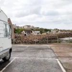 Caroline in front of a camper van parked near the port of Wick in Scotland