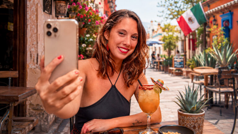 Smiling traveller taking a selfie in a colourful Mexican street