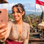 Caroline taking a selfie in Indonesia, with the Indonesian flag in the background