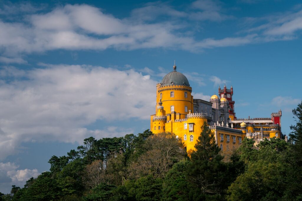 The yellow and red Pena Palace in Sintra on its wooded hill