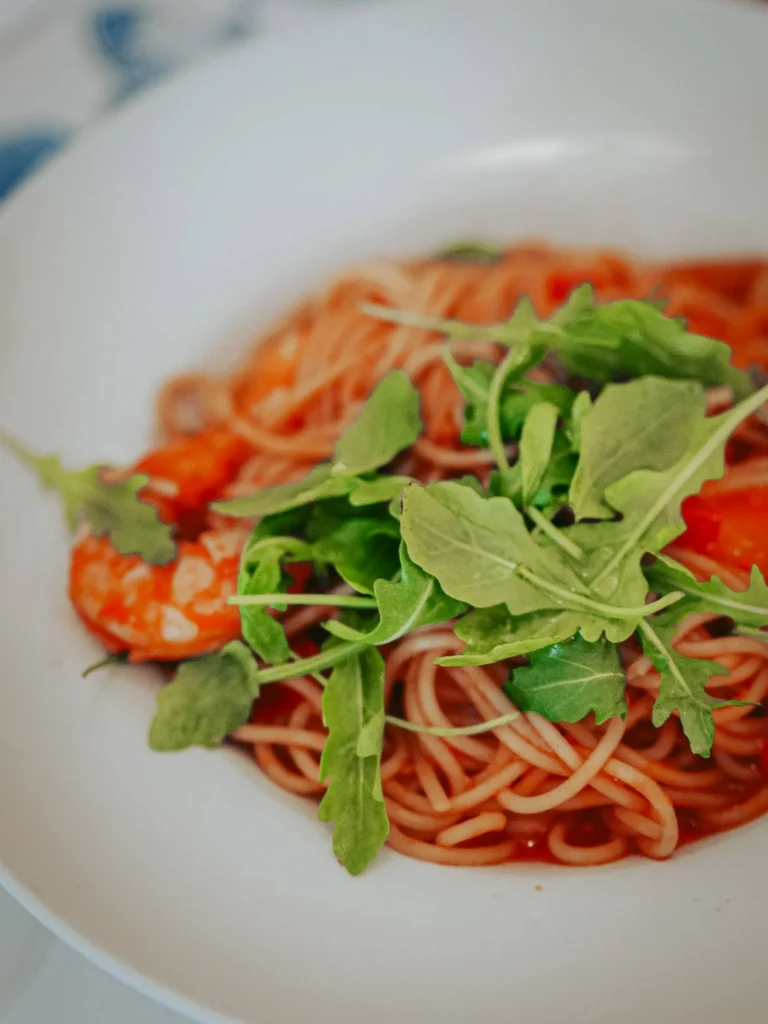 Plate of gambas spaghetti in bisque sauce topped with rocket at Nikita restaurant in Tavira, Algarve