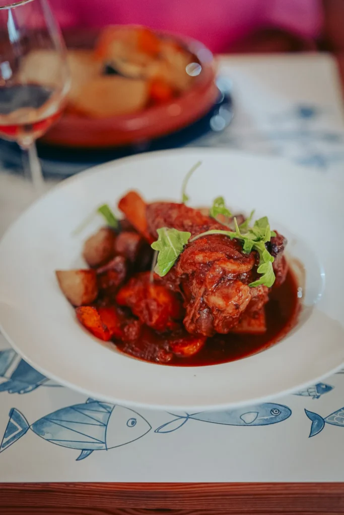 Lamb shank served with roasted vegetables and sauce at Nikita restaurant in Tavira, Algarve