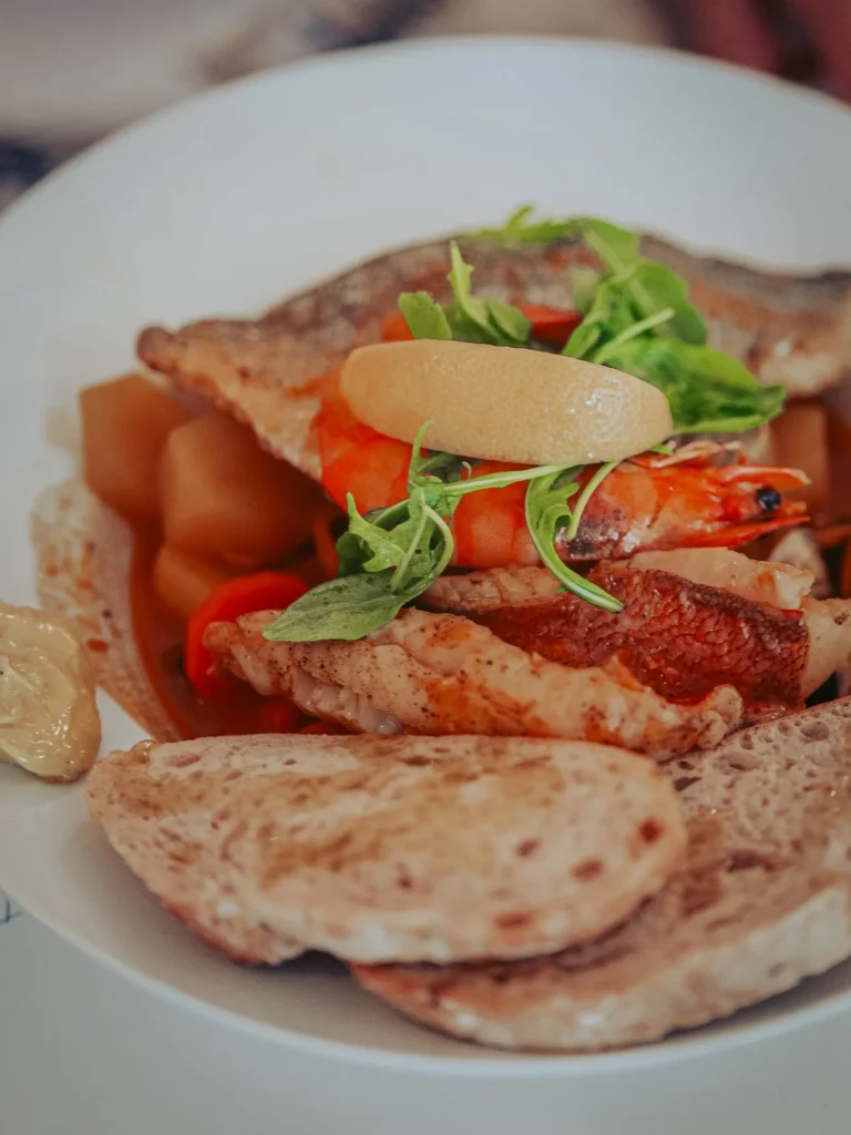 Bouillabaisse with fish, prawn, vegetables, fresh herbs and bread at Nikita restaurant in Tavira, Algarve