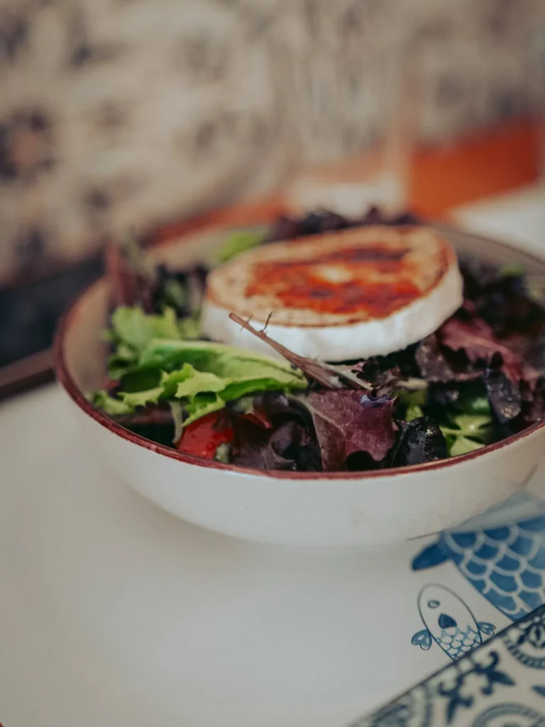 Warm goat cheese salad served in a bowl on a decorated table at Nikita restaurant in Tavira, Algarve