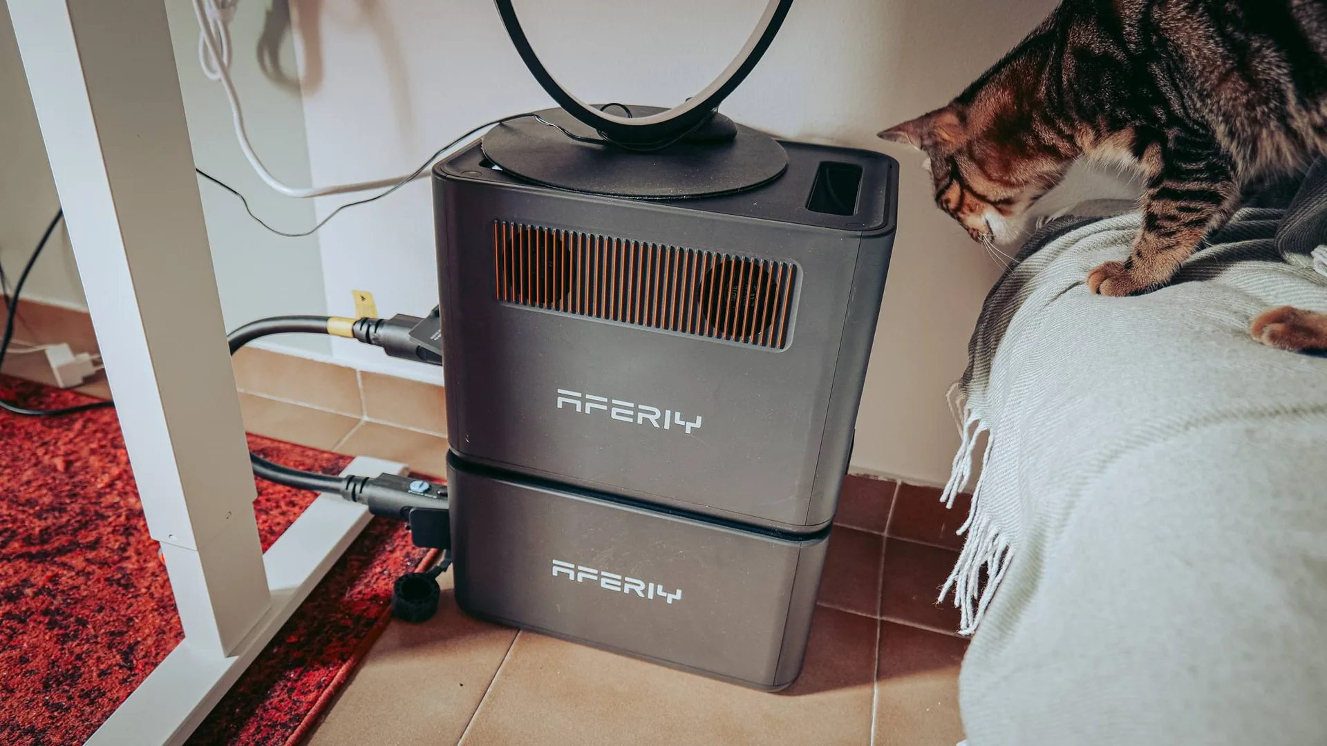 The Aferiy Nomad 1800 Pro station stacked on its P180-B extension battery, installed at home under a desk. The large connection cable links the two modules: the capacity increases (1024 Wh per module, up to 5120 Wh), but the power remains 1800 W.