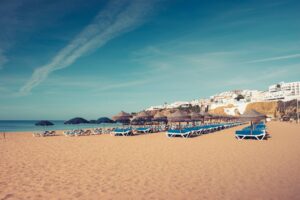 Albufeira beach with golden cliffs and straw umbrellas