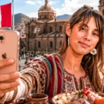 Caroline taking a selfie with her smartphone in front of the Machu Picchu citadel in Peru