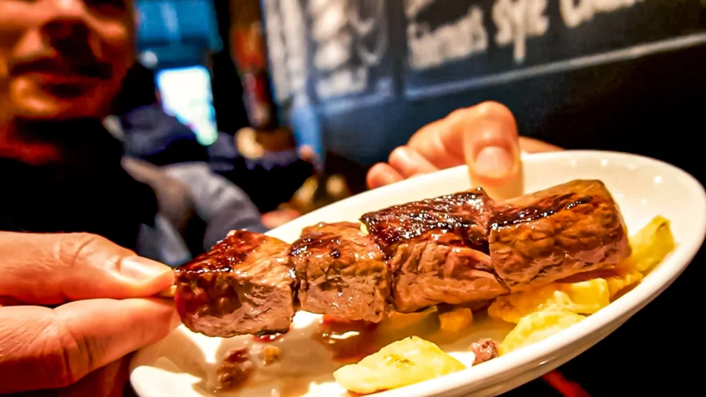 Grilled and caramelized aged beef skewer (txuleta brotxeta), served on a bed of potatoes in a pintxos bar in San Sebastián, November 2021.