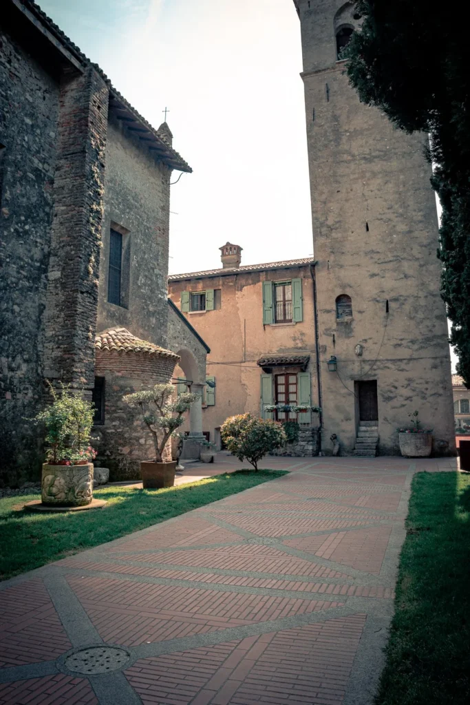Peaceful inner courtyard in Sirmione with old stone buildings and a tower