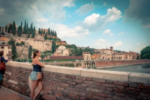 Caroline observes the historic buildings and hills of Verona from Castel San Pietro, Veneto panorama.
