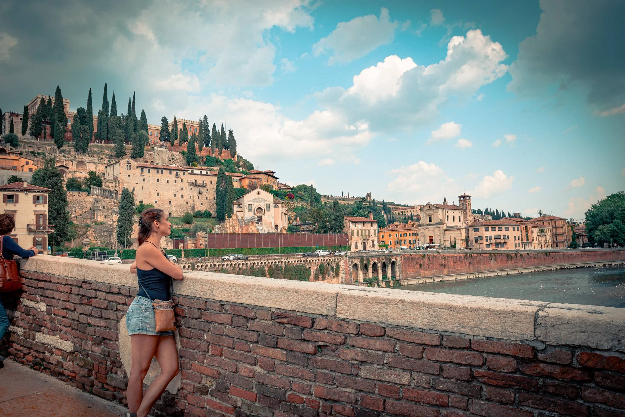 Caroline observes the historic buildings and hills of Verona from Castel San Pietro, Veneto panorama.