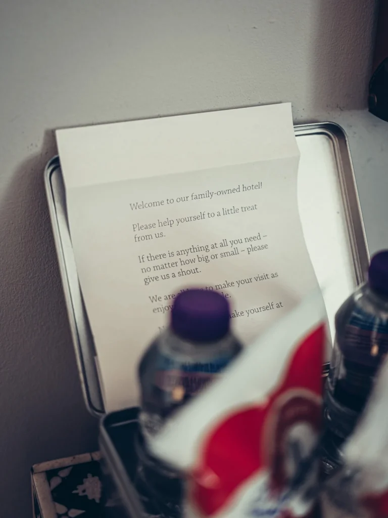 Welcome letter placed on a tray in a room at the Allan Park Hotel in Stirling, accompanied by bottles of water and snacks.