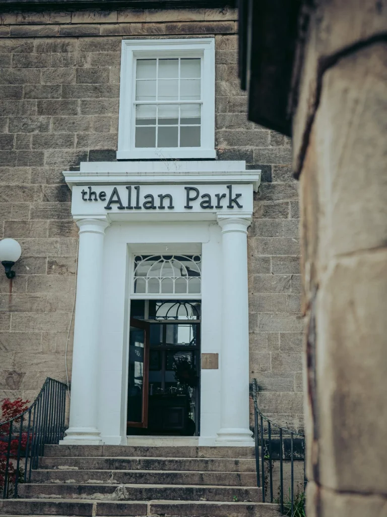 Main entrance of the Allan Park Hotel in Stirling, stone facade with white columns and outdoor staircase, taken in summer 2026.