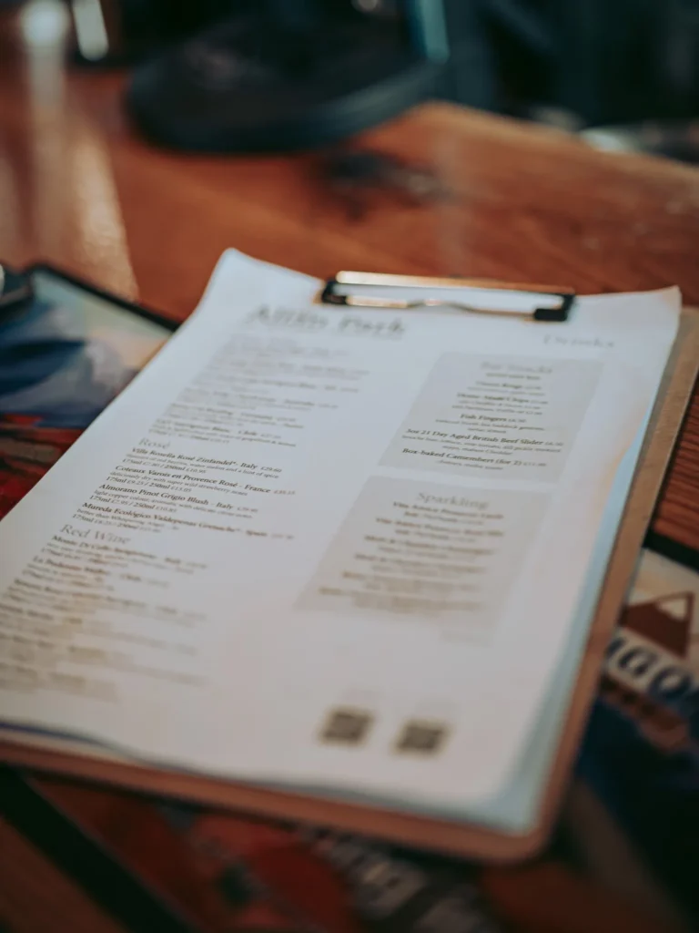 Drink and wine menu laid out on the wooden counter of the bar at the Allan Park Hotel in Stirling, Scotland, calm bar atmosphere in August 2026.