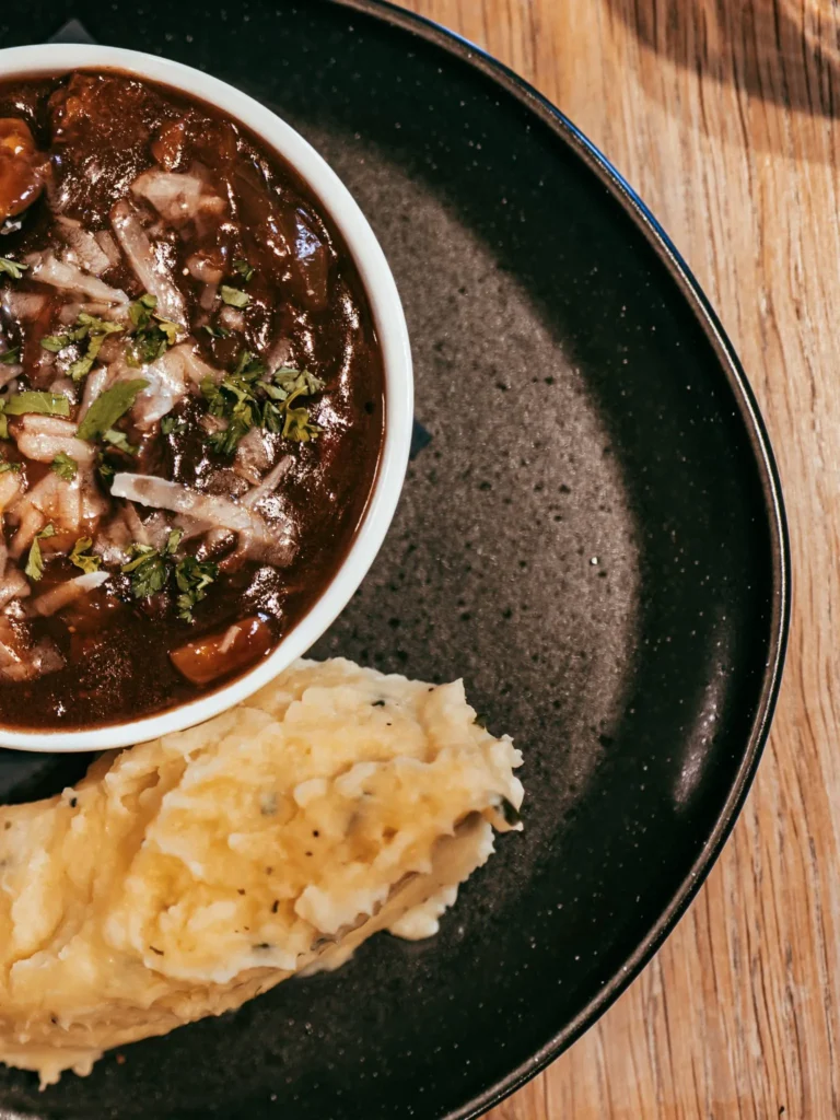 A dish from the restaurant of the Allan Park Hotel in Stirling consisting of a Scottish stew served with mashed potatoes, presented on a black plate in August 2026.