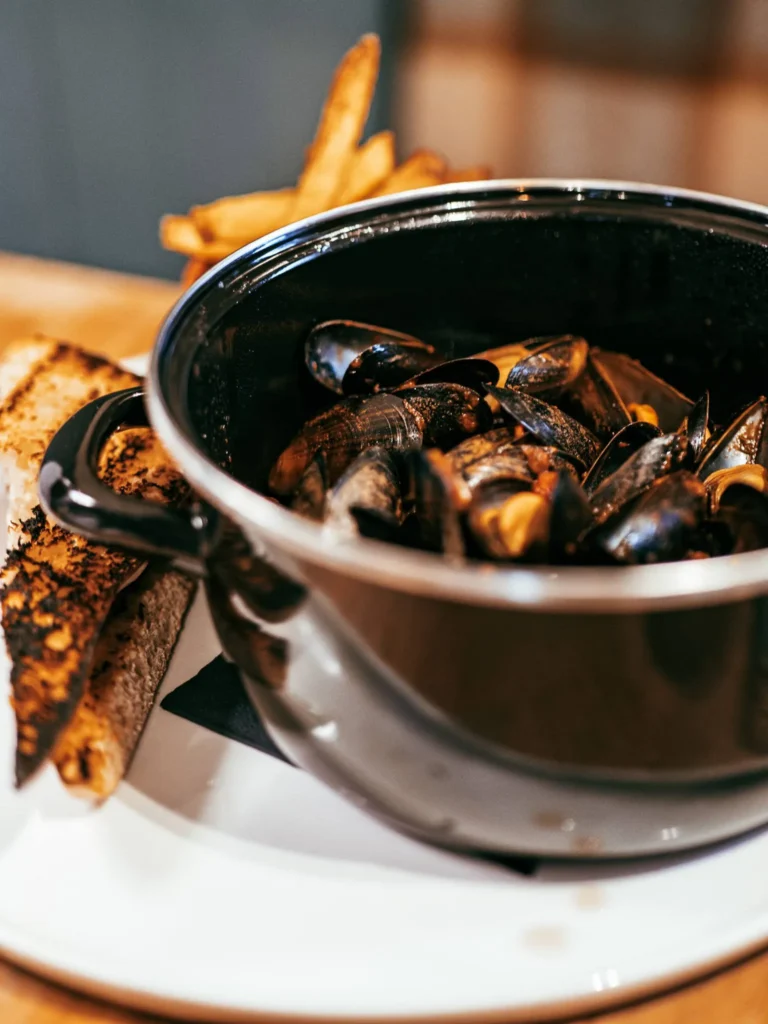 Mussels served in a black pot with fries and a slice of toasted bread, a typical dish from the restaurant at Allan Park Hotel in Stirling in August 2026.