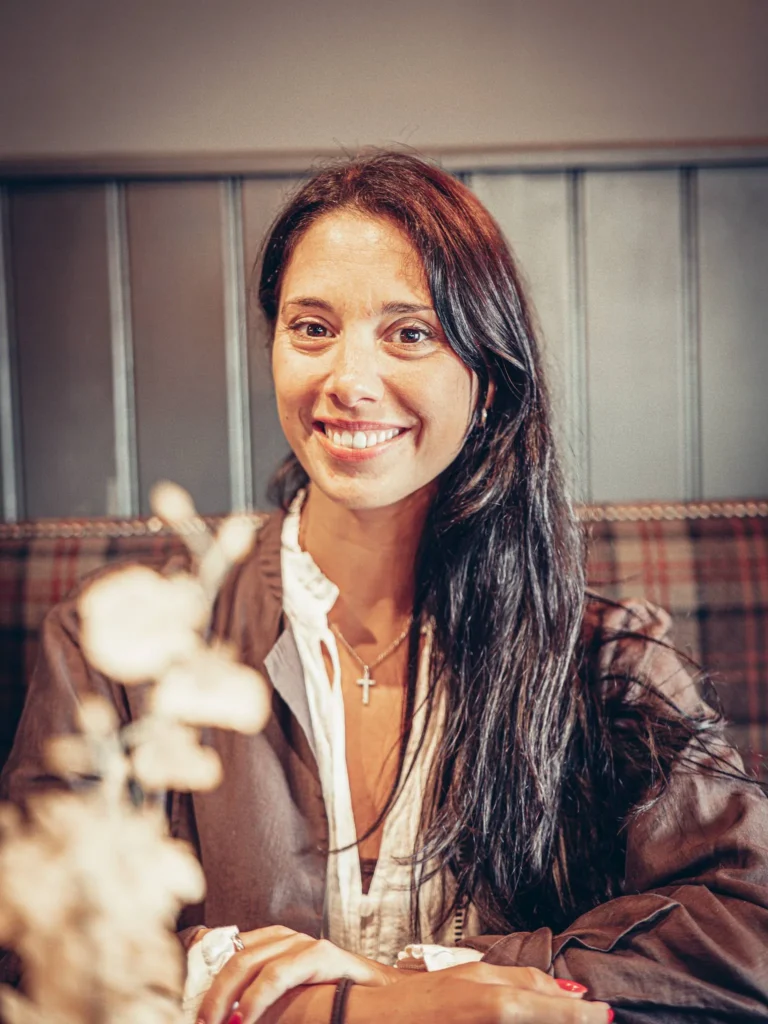 Caroline sitting at a table in Ben Nevis Bar in Fort William, warm atmosphere of the Scottish Highlands in August.