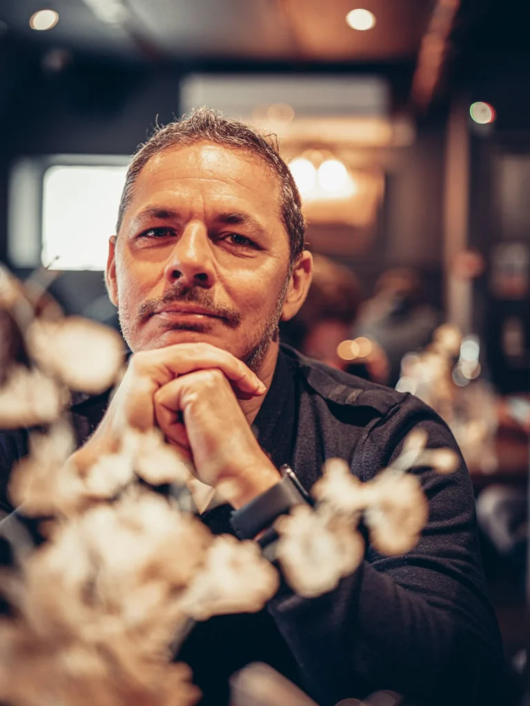 Xavier sitting at a table in Ben Nevis Bar in Fort William, warm and dimly lit atmosphere in the Scottish Highlands in August 2026.