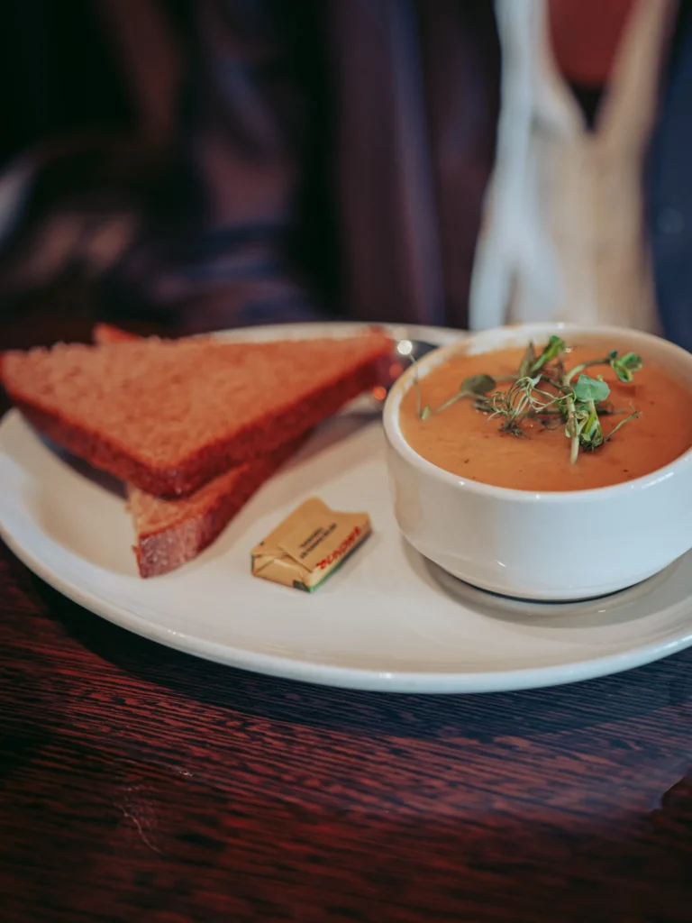 Soup of the day served with two slices of bread and a portion of butter at the Ben Nevis Bar in Fort William, with a broth of mussels marked under the vegetables.
