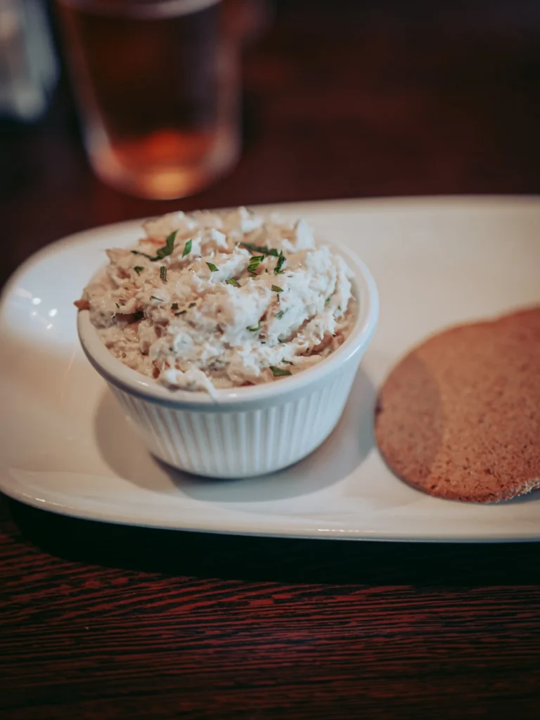 Smoked haddock pâté ramekin served with an oatcake on a wooden table at the Ben Nevis Bar in Fort William, closer to a dense terrine than a pâté.