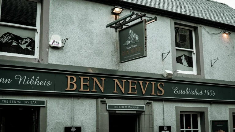 The frontage of the Ben Nevis Bar in Fort William, a historic pub showing the date 1806, its sign facing the High Street.