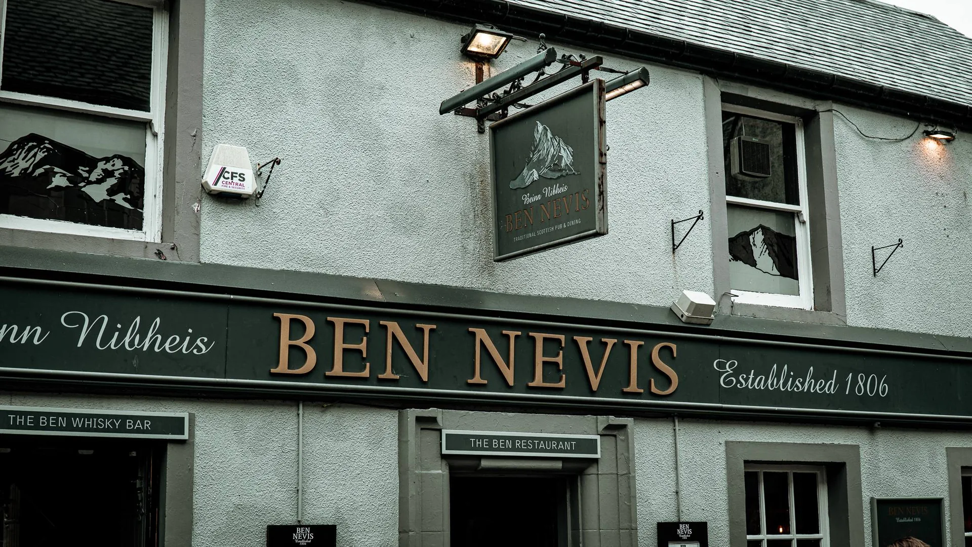 The frontage of the Ben Nevis Bar in Fort William, a historic pub showing the date 1806, its sign facing the High Street.