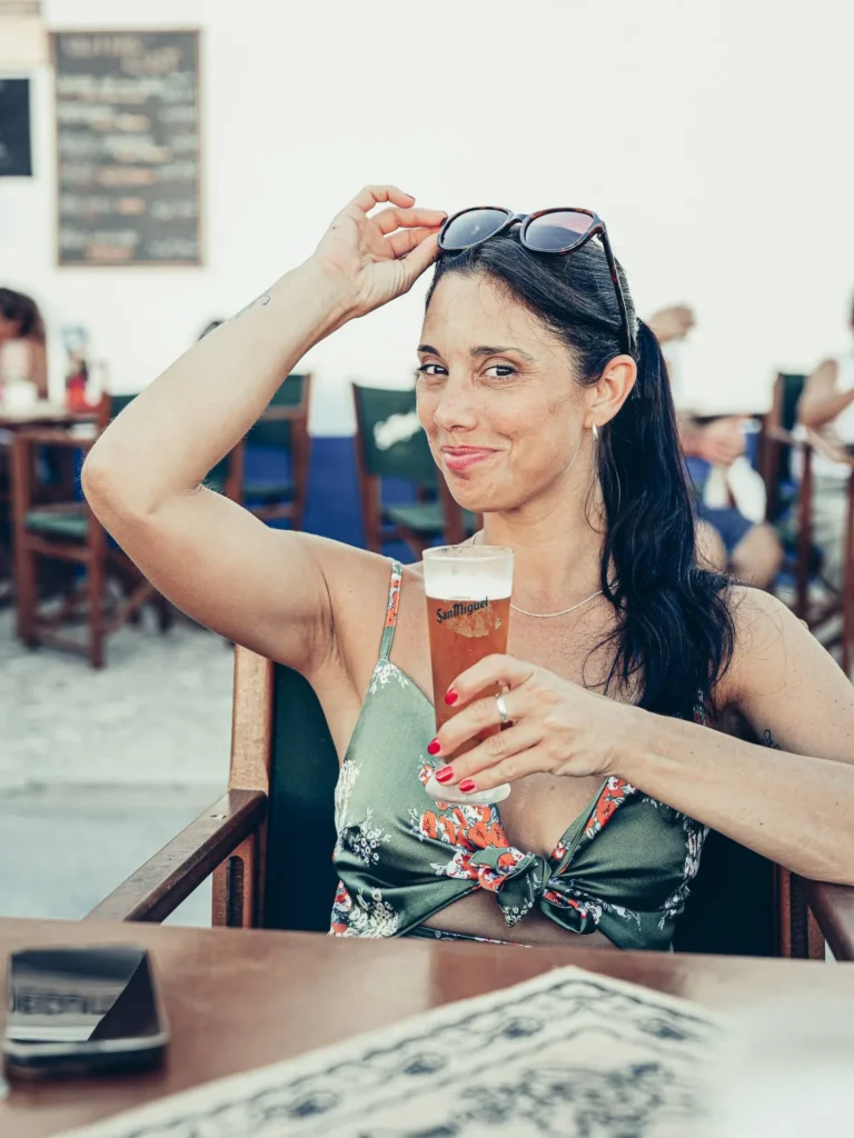 Caroline on the terrace at Bodeguita Salinas in Tavira, a San Miguel beer in hand on a summer day in the Algarve.