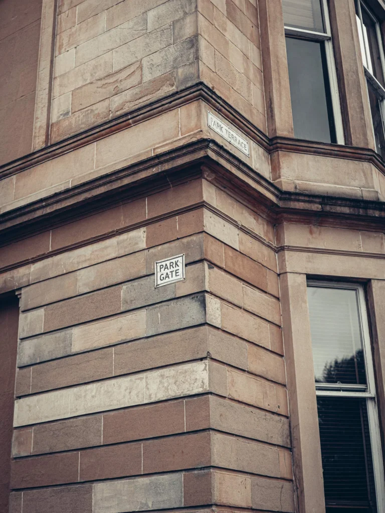 Corner of a blond sandstone Victorian building with bay windows, in the Park Circus area of Glasgow. These canted bay windows are characteristic of late nineteenth-century tenements and marked a more expensive class of flat.