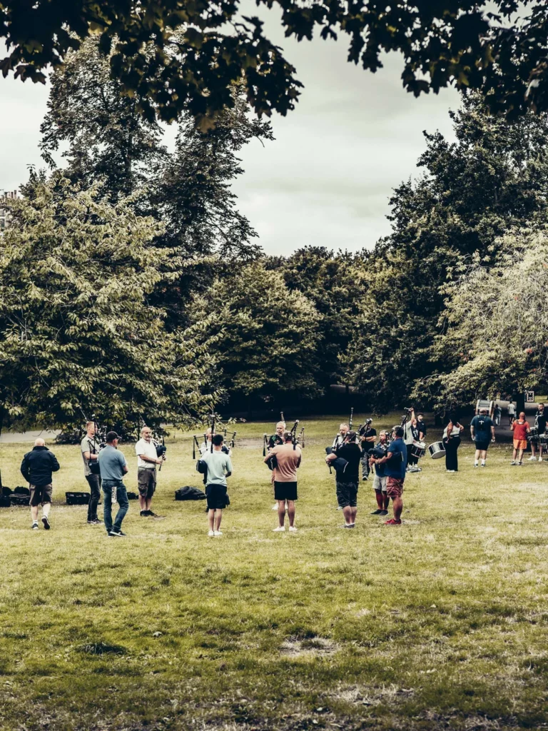 A pipe band rehearsing in a park in Glasgow.