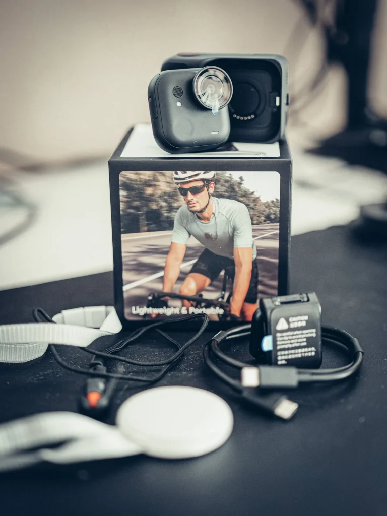 The full contents of the Insta360 GO Ultra box: the camera on its Action Pod, the lanyard, the magnetic clip, the mount and the USB-C cable laid out.