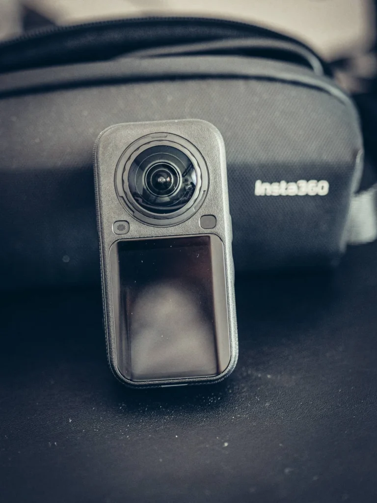 Insta360 X6 facing in front of its Insta360 carrying case