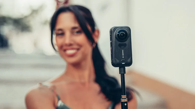 Caroline is filming with the Insta360 X6 mounted on a selfie stick outdoors.