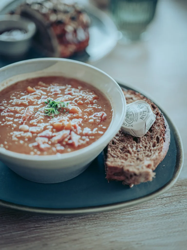Ham Hock and Lentil Soup served with a slice of wholemeal bread and a portion of butter at the Linnhe Storehouse and Cafe at Portnacroish, Argyll.