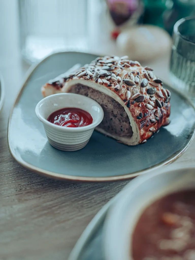 Seeded sausage roll served with a small pot of sauce at the Linnhe Storehouse and Cafe at Portnacroish, Argyll.