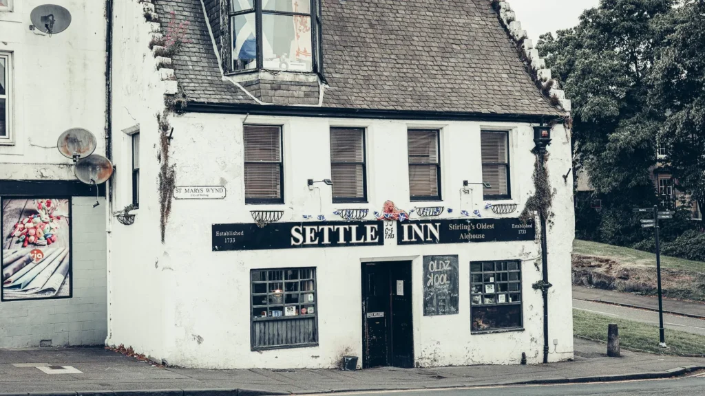 Facade of the Settle Inn, in Stirling, with its black sign. The pub, built in 1733 according to CAMRA, is presented as the oldest in the city.