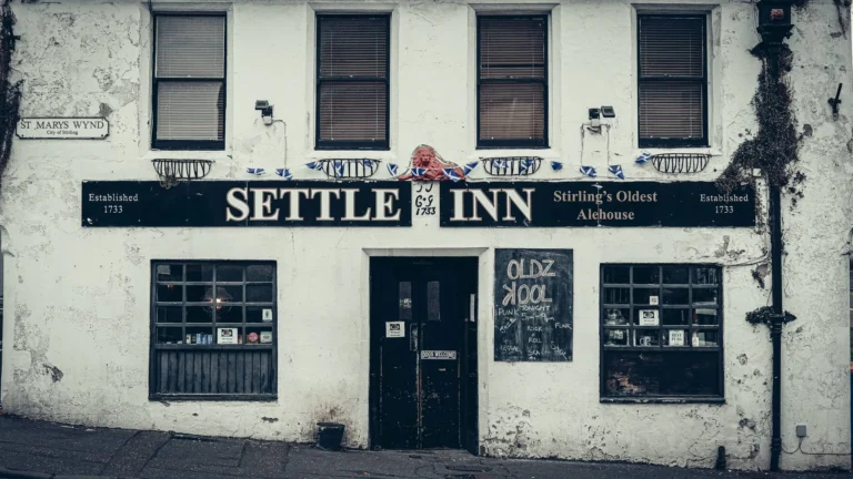 The whitewashed facade of the Settle Inn in Stirling, a listed 1733 building whose sign bills it as Stirling's Oldest Alehouse.