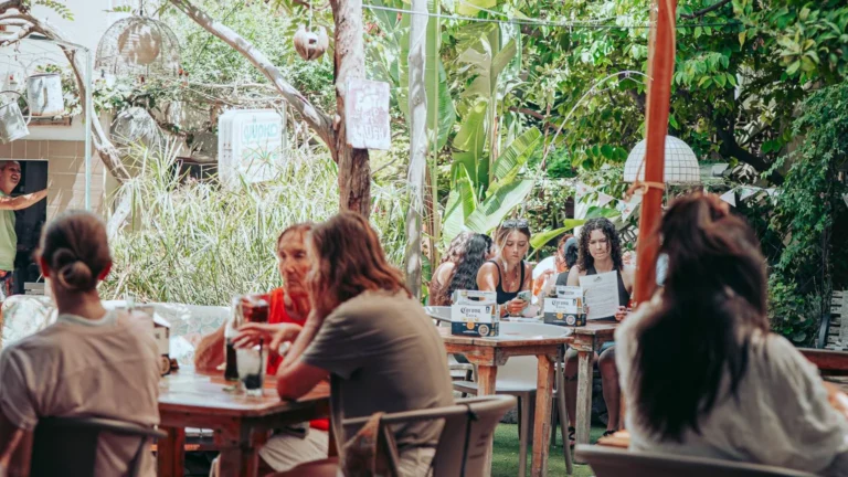 The garden of the restaurant The Garden Bar and Grill in Lagos, Algarve, with its occupied tables under large umbrellas and its dense vegetation.