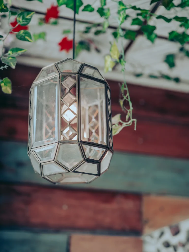 Faceted glass pendant lit among decorative foliage in the warm interior of The Geographer, Fort William.